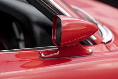 Side view mirror on red classic car