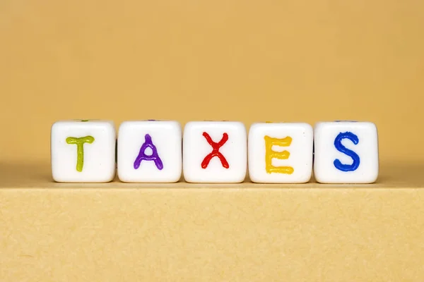 Weiße Blöcke Mit Buntem Taxes Text Vor Gelbem Hintergrund — Stockfoto