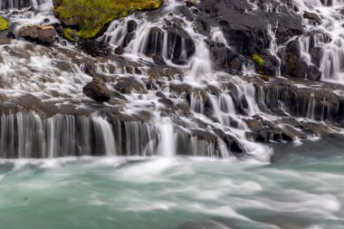 Hraunfossar benzersiz bir sudur İzlanda 'da su lav taşlarının altından akar..