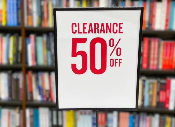 50 percent sale sign board in front of bookshelf in the book store.