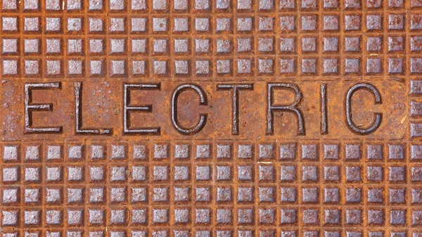 Elektrischer Text Auf Rostigen Mann Loch Cover Nahaufnahme — Stockfoto