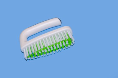 New plastic cleaning brush on blue background with copy spaace.