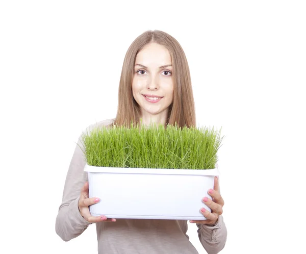 Jonge vrouw die pot van groen gras — Stockfoto