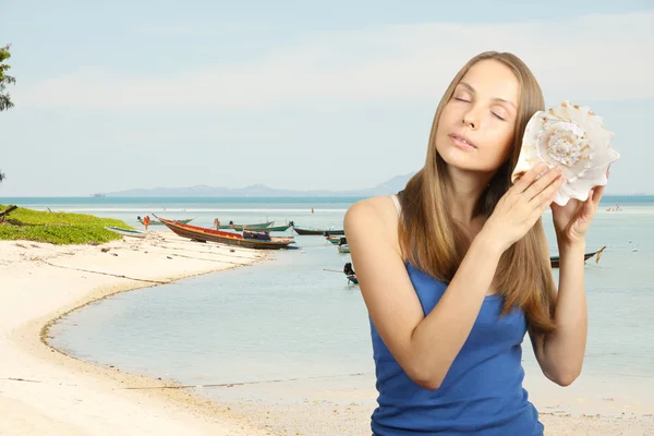 海と巻貝を聴く女性 — ストック写真