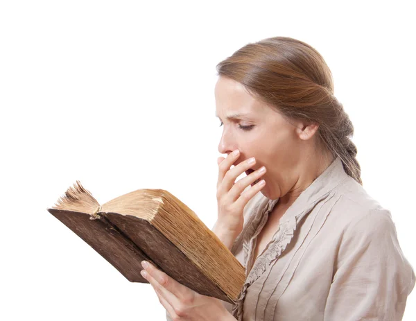 Bocejo menina lendo um livro chato — Fotografia de Stock