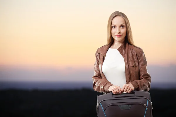 Femme avec une valise au coucher du soleil — Photo