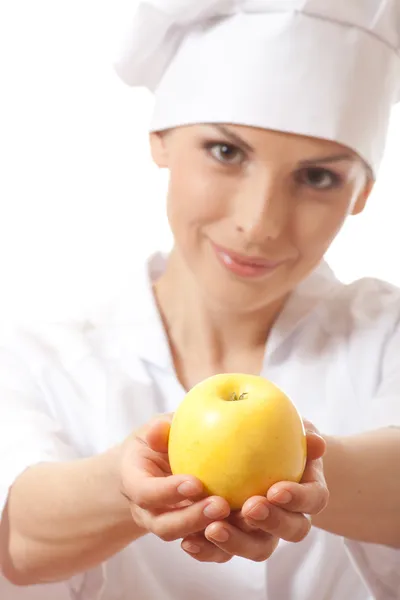 Mulher sorridente cozinheiro com maçã amarela — Fotografia de Stock
