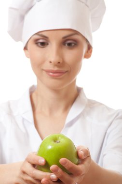 Yeşil elma ile gülümseyen kadın aşçı