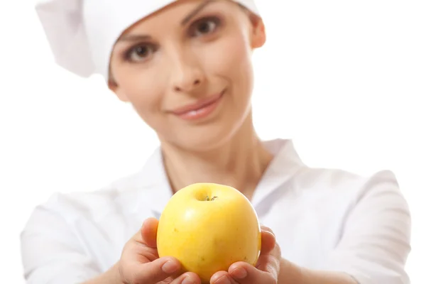 Mujer sonriente cocinera con manzana amarilla — Foto de Stock