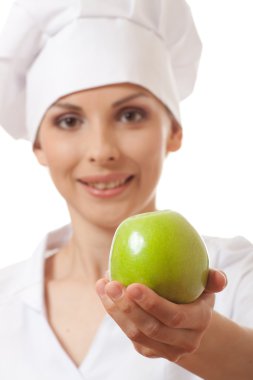 Yeşil elma ile gülümseyen kadın aşçı