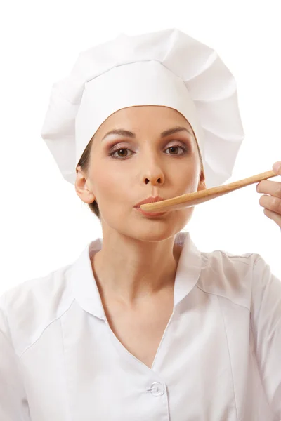 Mulher cozinheiro comer com colher, isolado em branco — Fotografia de Stock