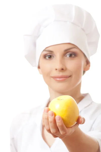 Sarı elma ile gülümseyen kadın aşçı — Stok fotoğraf