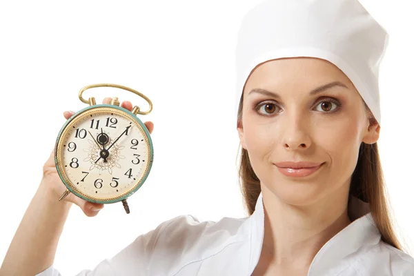 Female doctor holding alarm clock, isolated Stock Picture