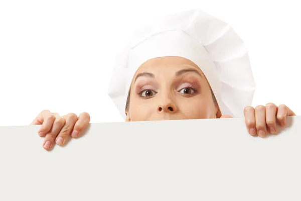 Woman cook looking over paper sign billboard. — Stock Photo, Image