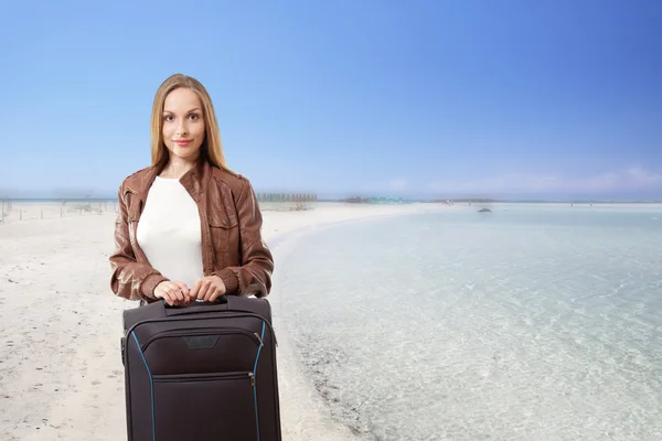 Femme avec une valise sur la plage — Photo