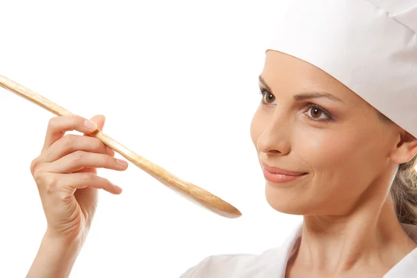 Mujer cocinera comiendo con cuchara, aislada en blanco — Foto de Stock