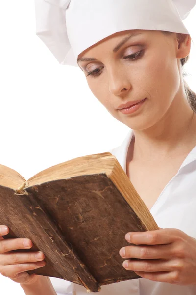 Nainen kokki käsittelyssä reseptejä kirja — kuvapankkivalokuva