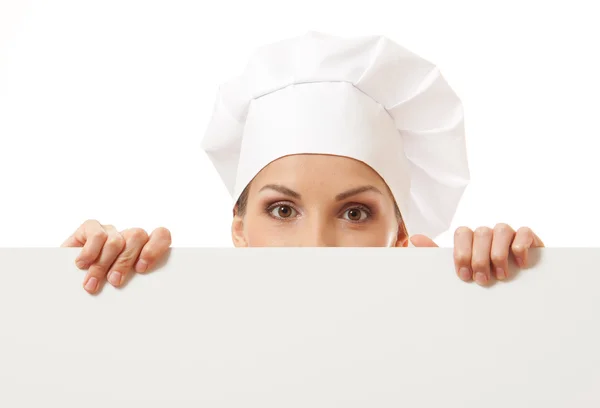 Mulher cozinheiro olhando sobre cartaz sinal de papel . — Fotografia de Stock