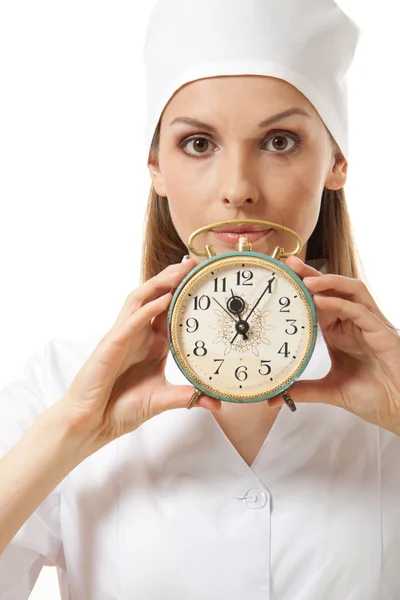 Γυναίκα γιατρό, κρατώντας ρολόι συναγερμών, απομονωμένη — Φωτογραφία Αρχείου