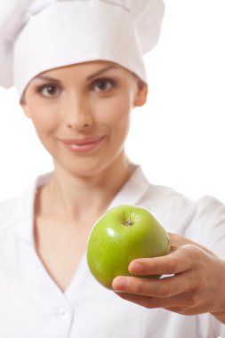 Yeşil elma ile gülümseyen kadın aşçı