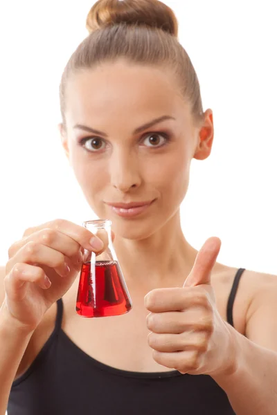 Mulher de fato desportivo segura frasco com líquido vermelho — Fotografia de Stock