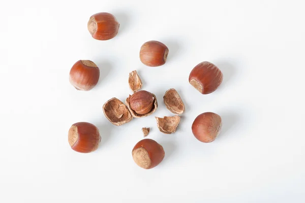 Peeled hazelnut among unpeeled, isolated on white — Stock Photo, Image