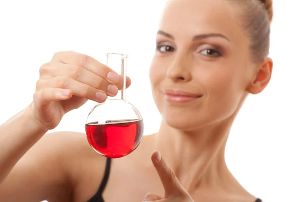 Woman in sports suit holds flask with red liquid — Stock Photo, Image