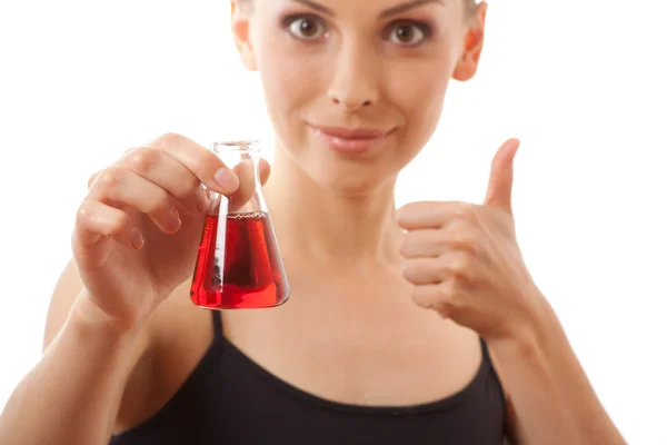 Mujer en traje deportivo sostiene frasco con líquido rojo — Foto de Stock