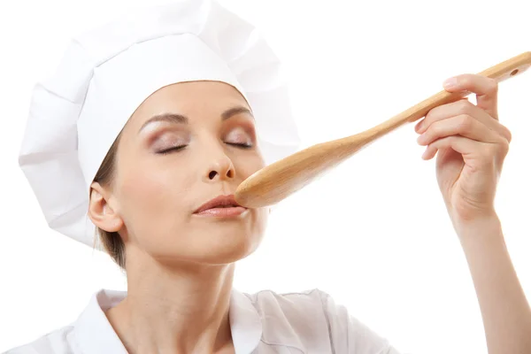 Mujer cocinera comiendo con cuchara, aislada en blanco — Foto de Stock