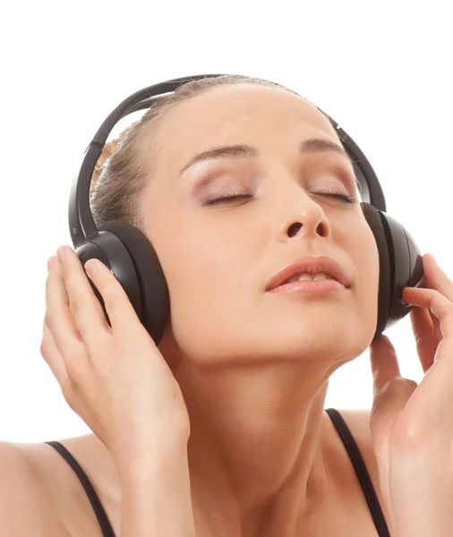 Женщина слушает музыку в наушниках, на белом — стоковое фото
