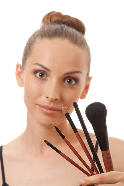 Mladá žena ukazující její make-up štětce — Stock fotografie