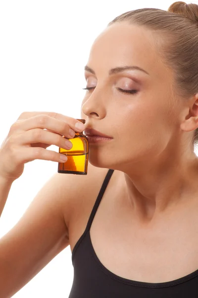 Ung kvinna med en flaska medicin — Stockfoto