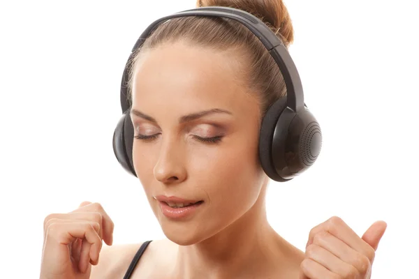 Donna che ascolta musica con le cuffie, su bianco — Foto Stock