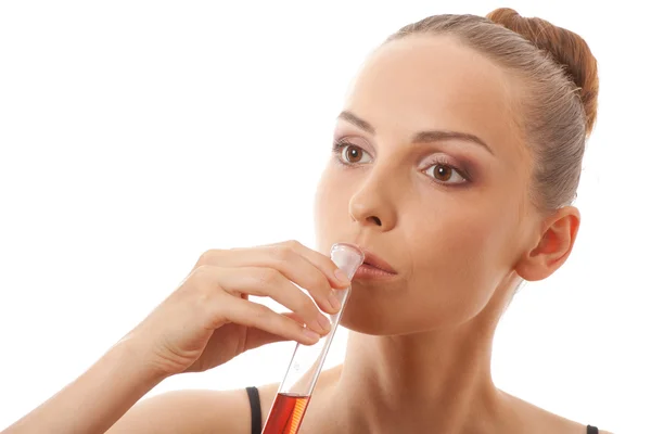 Vrouw drinkt rode vloeistof uit een reageerbuis — Stockfoto