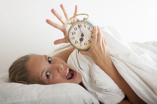 Young sleeping woman and alarm clock in bed — Stock Photo, Image