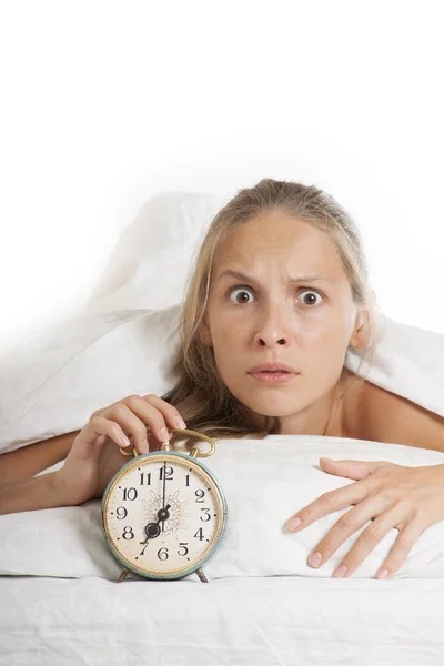 Mujer joven dormida y despertador en la cama — Foto de Stock