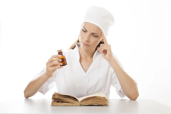 Mujer doctora o enfermera leyendo libro viejo — Foto de Stock