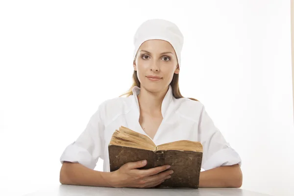 Mujer doctora o enfermera leyendo libro viejo — Foto de Stock