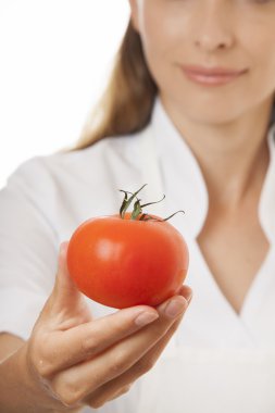 kırmızı domates ile gülümseyen kadın aşçı