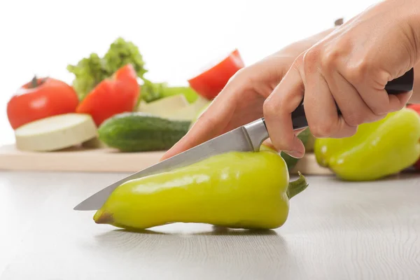 Mani femminili con coltello, taglio pepe — Foto Stock