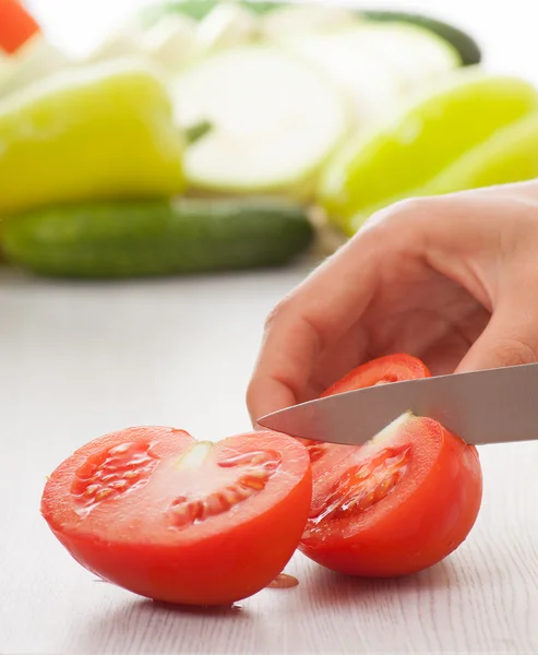 Manos femeninas con cuchillo, tomates cortados — Foto de Stock