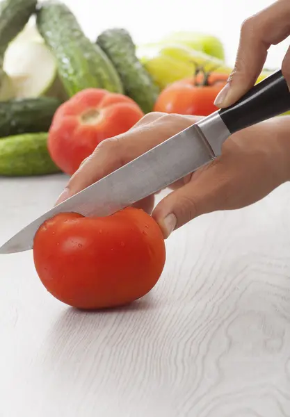 Manos femeninas con cuchillo, tomates cortados — Foto de Stock