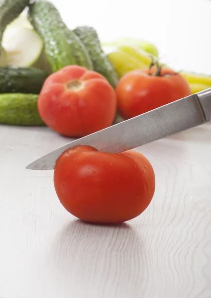 Manos femeninas con cuchillo, tomates cortados — Foto de Stock