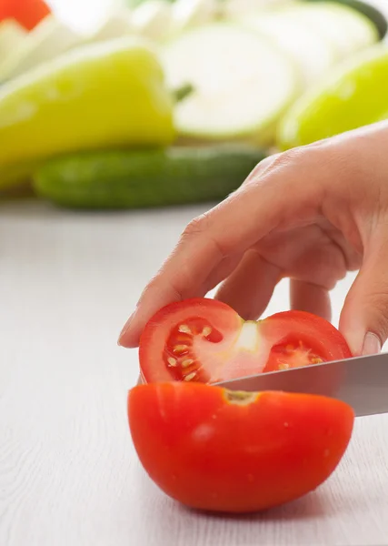 Manos femeninas con cuchillo, tomates cortados — Foto de Stock