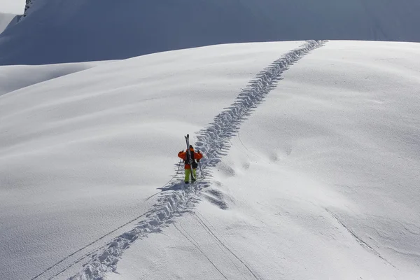 雪に覆われた山に登るスキーヤー — ストック写真