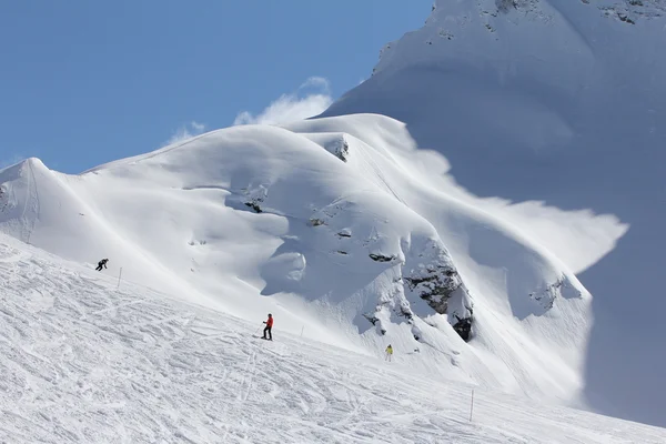 Esquiadores bajando la pista en la estación de esquí —  Fotos de Stock