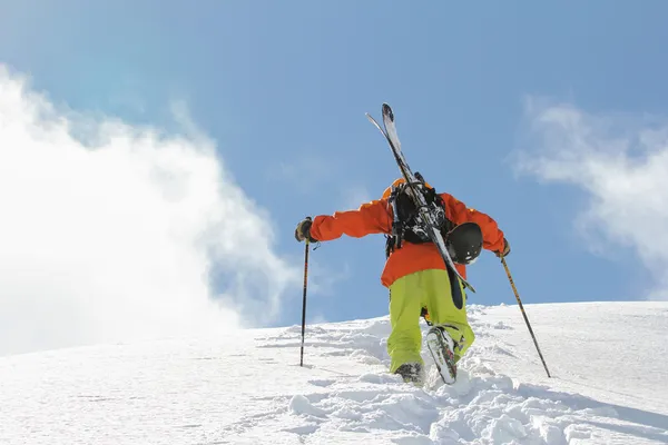 Skieur escalade une montagne enneigée — Photo