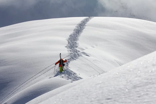 雪に覆われた山に登るスキーヤー — ストック写真