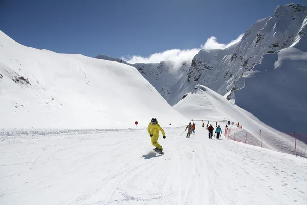 Skiërs naar beneden de helling in skiresort — Stockfoto