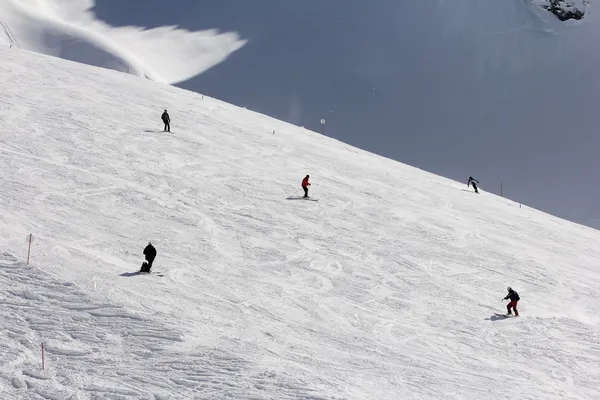 Skiërs naar beneden de helling in skiresort — Stockfoto